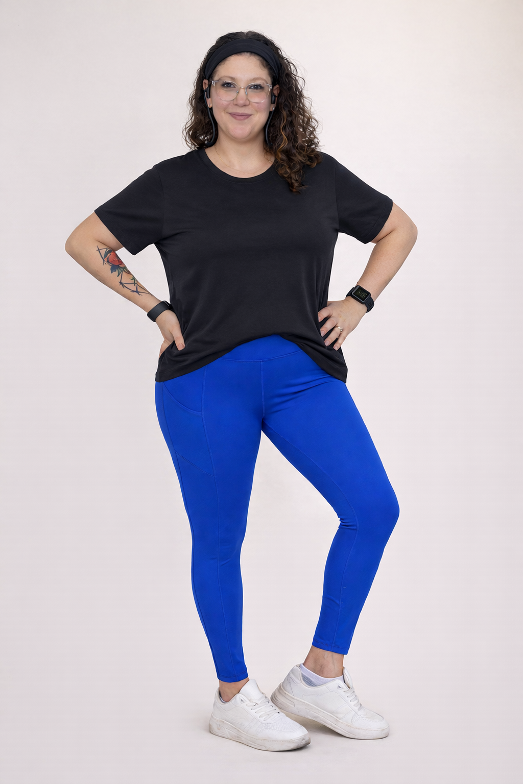 Person wearing a black t-shirt and blue leggings on a white background