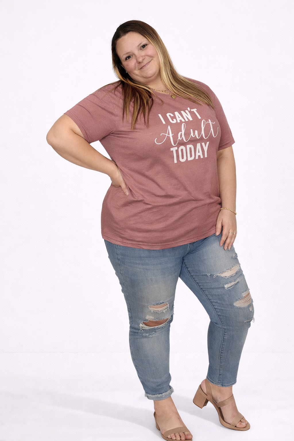 Woman wearing a mauve t-shirt with text and ripped jeans on a white background