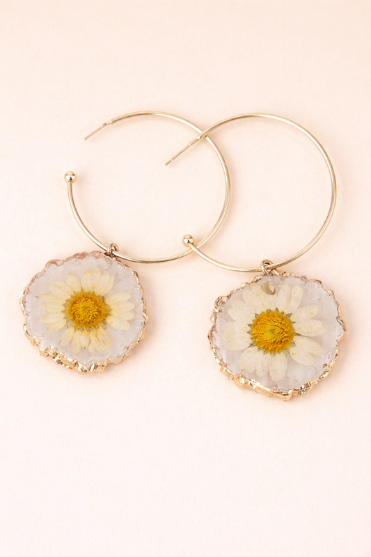 Gold hoop earrings with floral accents on a light background