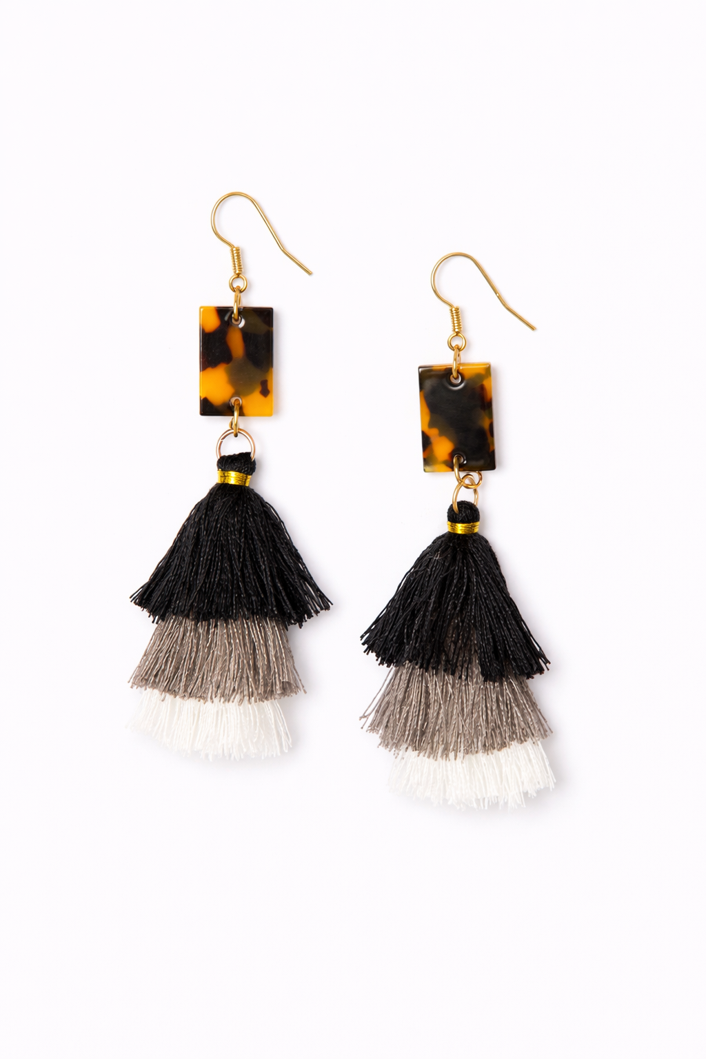 Pair of earrings with tortoiseshell square tops and tassel bottoms on a white background