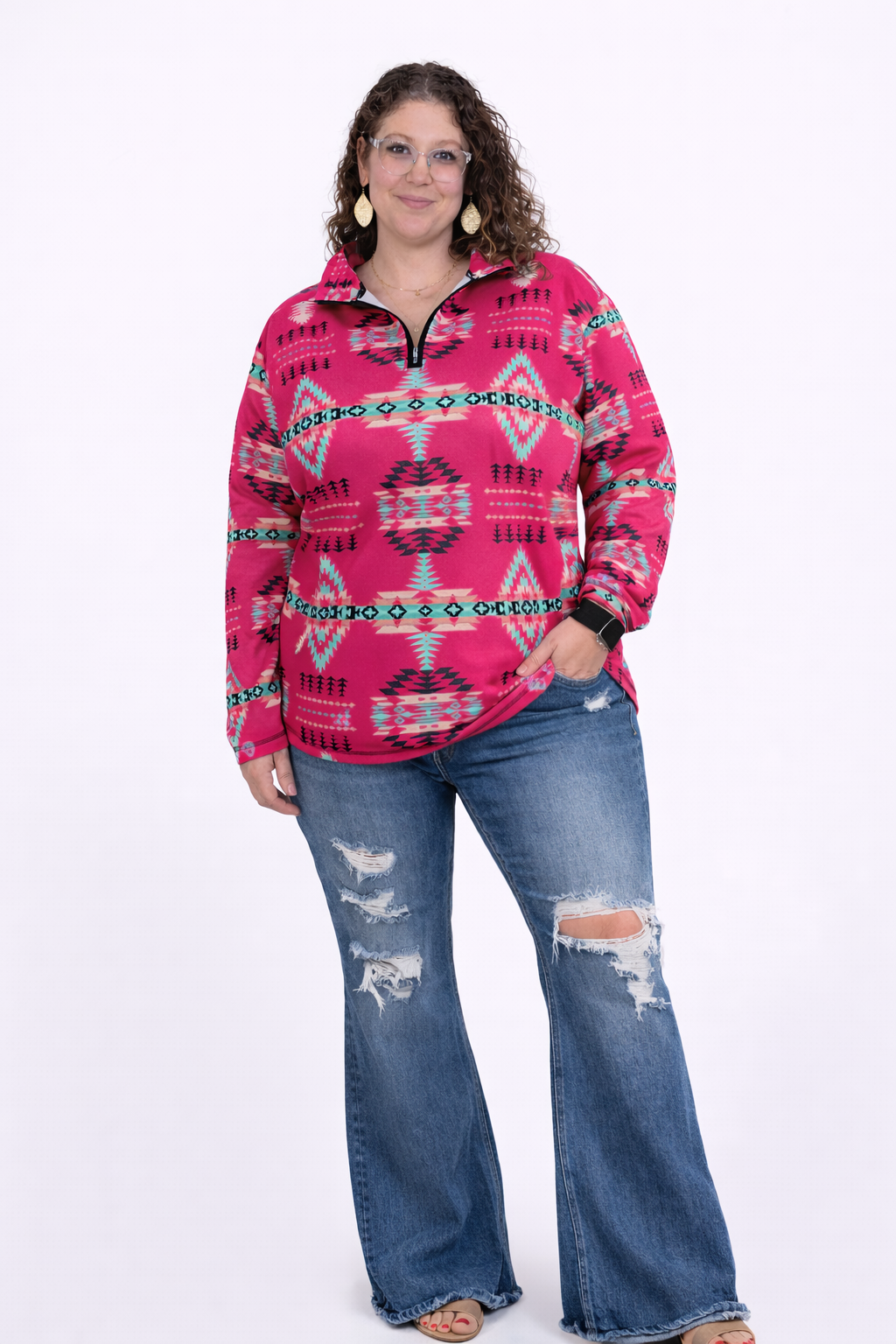 Woman wearing a pink patterned top and blue jeans on a white background