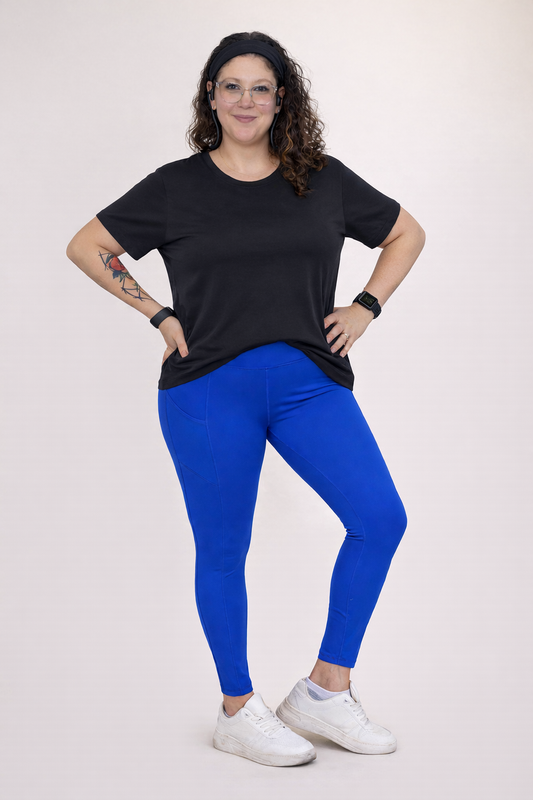 Person wearing a black t-shirt and blue leggings on a white background