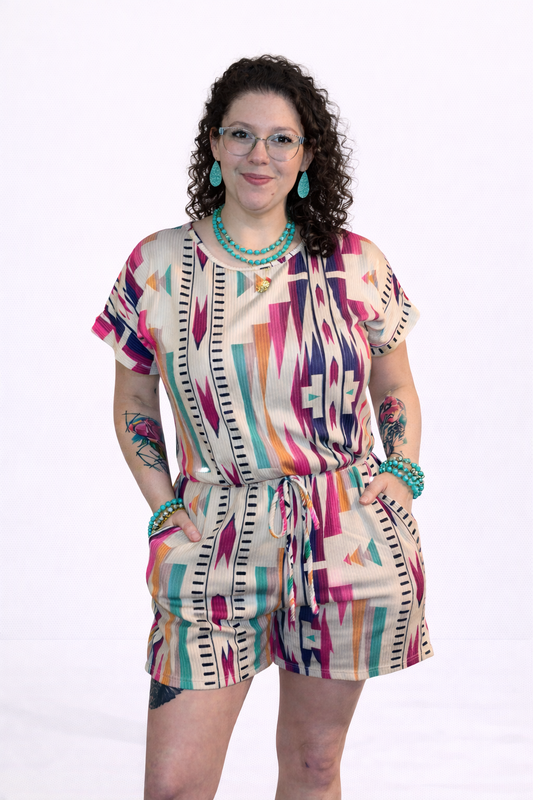 Woman wearing a colorful patterned romper on a white background