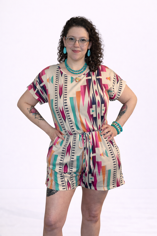 Woman wearing a colorful patterned romper on a white background