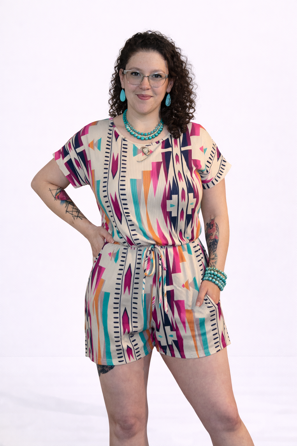 Woman wearing a colorful patterned romper on a white background