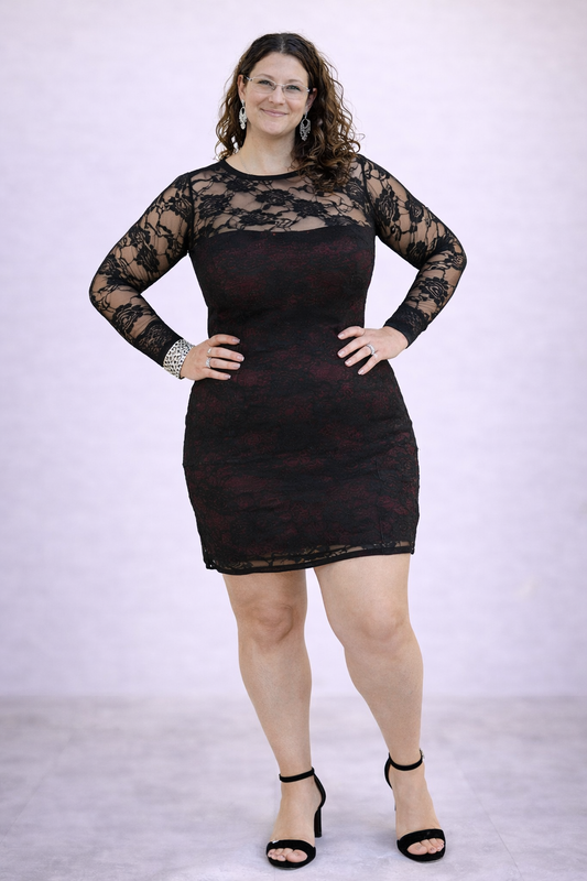 Woman wearing a black lace dress against a white background