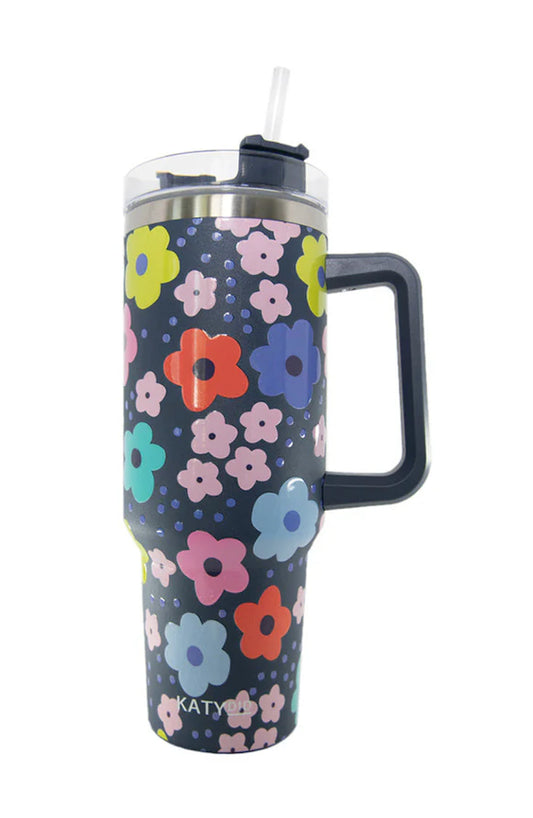 Floral-patterned mug with handle and straw on a white background