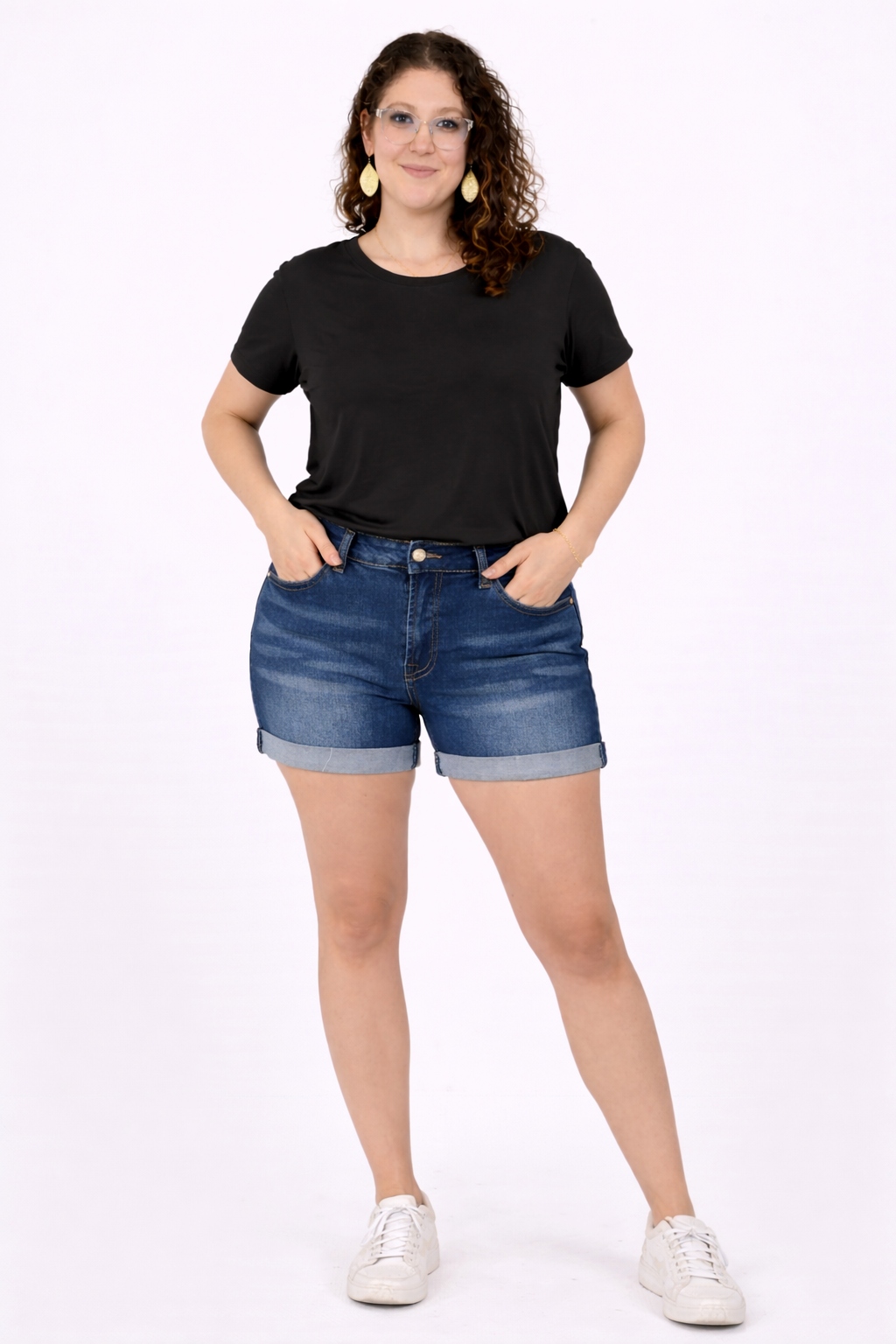 Woman wearing a black t-shirt and blue denim shorts on a white background