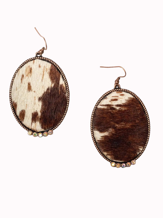 Cowhide earrings with bronze accents on a white background