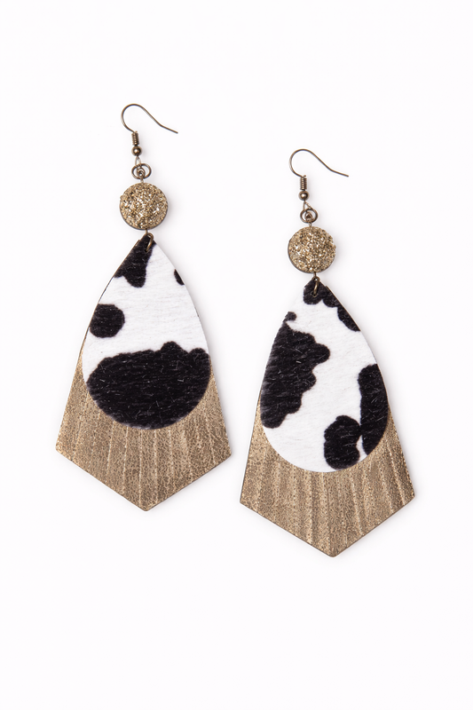 Cow print earrings with gold accents on a white background